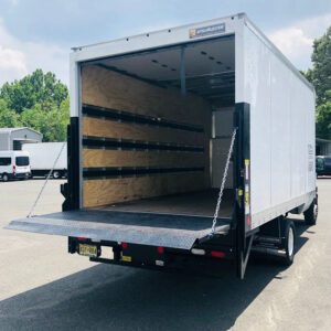 A truck with its back door open parked in the lot.