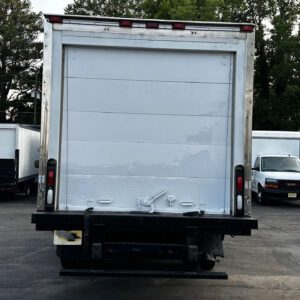 A truck with its back door open parked in the parking lot.